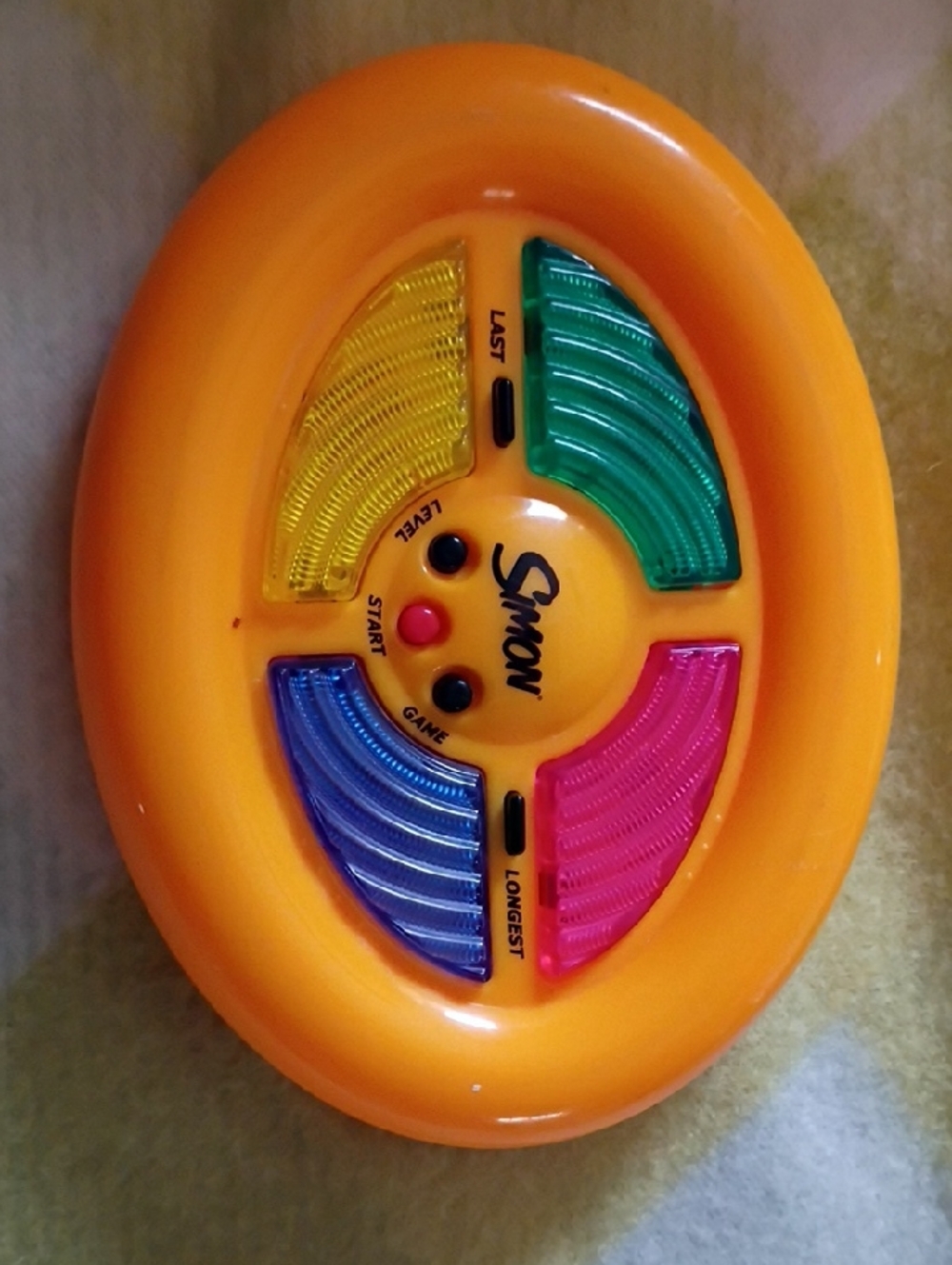 Simons Orange Handheld Memory Game with Yellow, Green, Blue and Pink Pads
